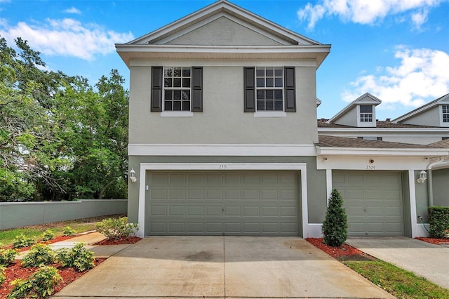 view of front facade featuring an attached garage, stucco siding, and driveway