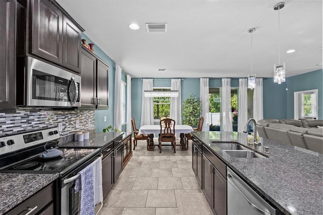 10514 Scenic Hollow Dr, Riverview, FL 33578 - kitchen with stainless steel appliances, a sink, backsplash, dark stone countertops, and recessed lighting