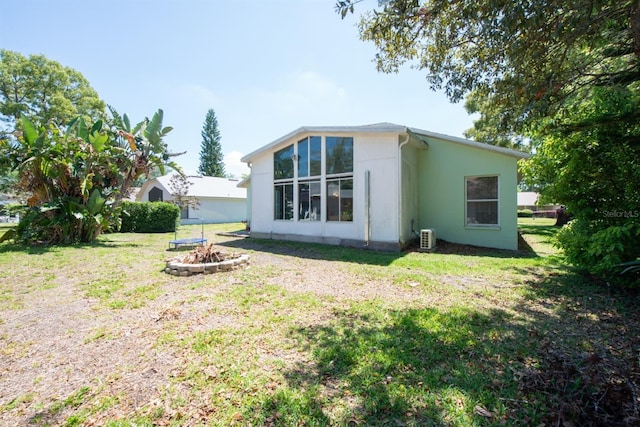 10321 Ravines Dr, New Port Richey, FL 34654 - rear view of property with an outdoor fire pit, a yard, and stucco siding