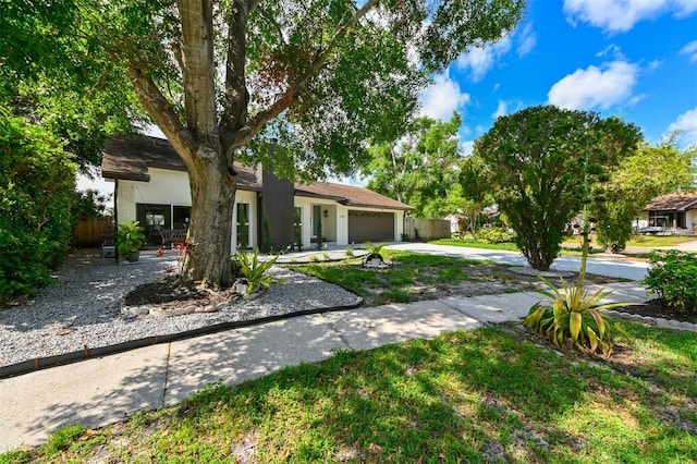 4520 Wescott Ln, Tampa, FL 33624 - view of front of house featuring driveway, a chimney, fence, a garage, and stucco siding