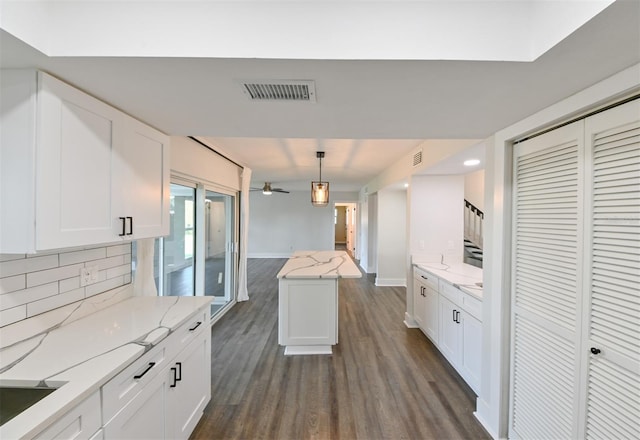 4520 Wescott Ln, Tampa, FL 33624 - kitchen with dark wood finished floors, visible vents, white cabinetry, and tasteful backsplash