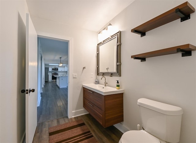 4520 Wescott Ln, Tampa, FL 33624 - half bath with baseboards, wood finished floors, vanity, and toilet