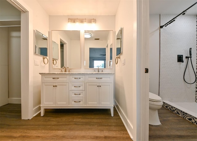 4520 Wescott Ln, Tampa, FL 33624 - full bathroom featuring a sink, double vanity, toilet, wood finished floors, and a shower