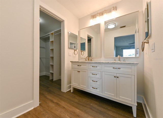 4520 Wescott Ln, Tampa, FL 33624 - bathroom with double vanity, wood finished floors, visible vents, and a sink