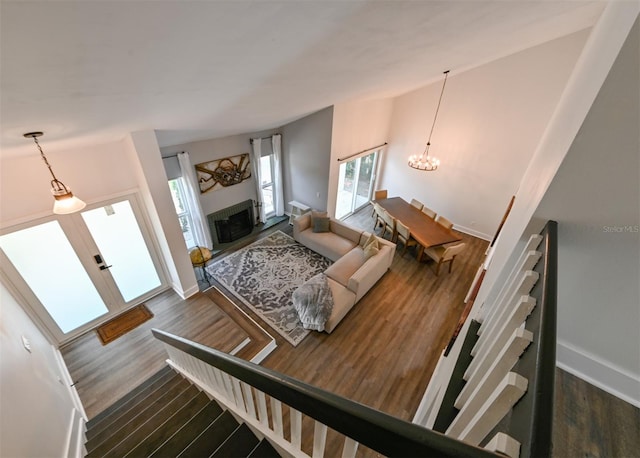 4520 Wescott Ln, Tampa, FL 33624 - living room featuring baseboards, a chandelier, wood finished floors, and a fireplace with raised hearth