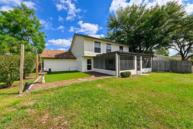 4520 Wescott Ln, Tampa, FL 33624 - back of house with a sunroom, fence, and a lawn