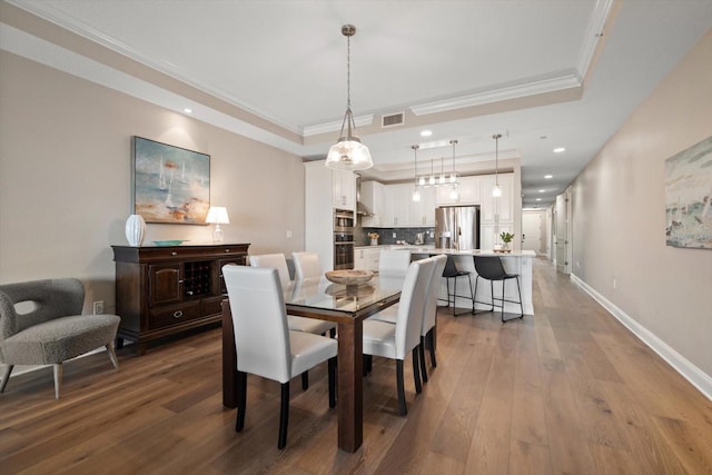 202 Windward Psge Unit 304, Clearwater Beach, FL 33767 - dining area featuring wood finished floors, a raised ceiling, crown molding, and recessed lighting