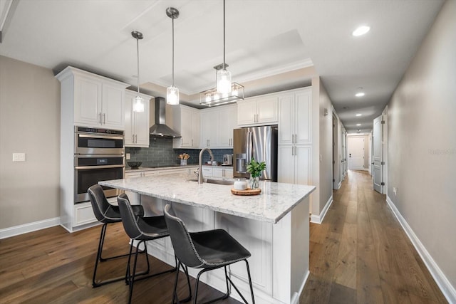 202 Windward Psge Unit 304, Clearwater Beach, FL 33767 - kitchen featuring stainless steel appliances, wall chimney exhaust hood, decorative backsplash, dark wood finished floors, and white cabinetry