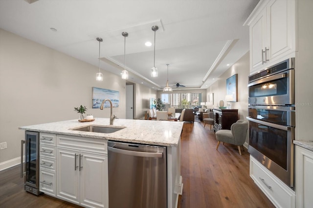 202 Windward Psge Unit 304, Clearwater Beach, FL 33767 - kitchen featuring stainless steel appliances, a raised ceiling, beverage cooler, dark wood finished floors, and white cabinetry