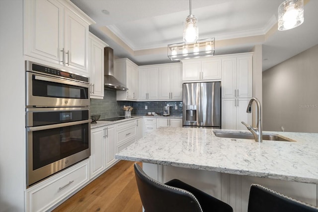202 Windward Psge Unit 304, Clearwater Beach, FL 33767 - kitchen with appliances with stainless steel finishes, wall chimney exhaust hood, white cabinetry, backsplash, and crown molding