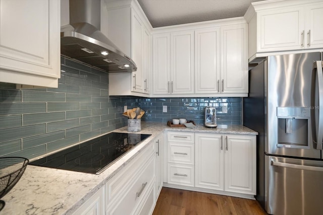 202 Windward Psge Unit 304, Clearwater Beach, FL 33767 - kitchen with stainless steel fridge, wall chimney range hood, black electric cooktop, and white cabinets
