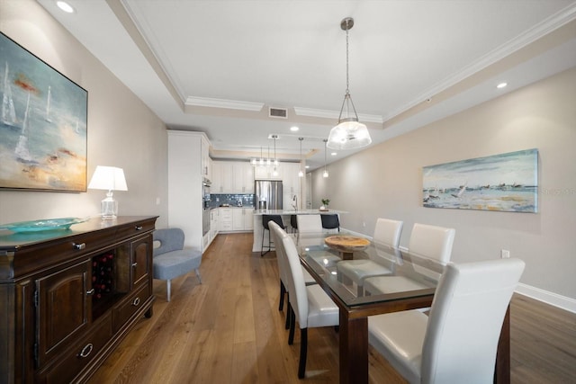 202 Windward Psge Unit 304, Clearwater Beach, FL 33767 - dining area featuring wood finished floors, ornamental molding, a raised ceiling, and recessed lighting
