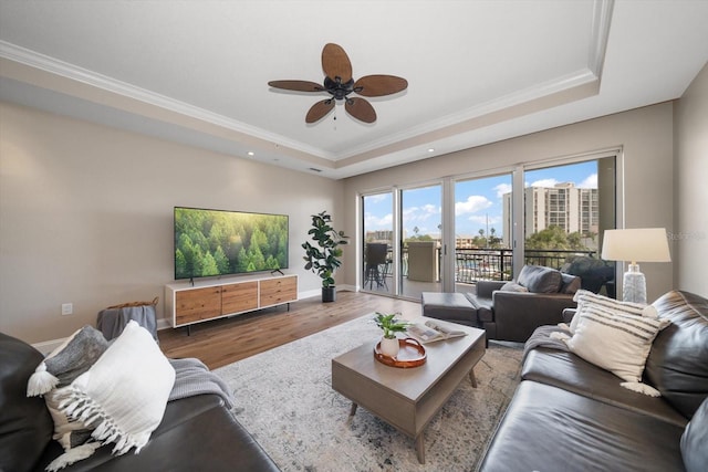 202 Windward Psge Unit 304, Clearwater Beach, FL 33767 - living area featuring a raised ceiling, ceiling fan, wood finished floors, plenty of natural light, and crown molding