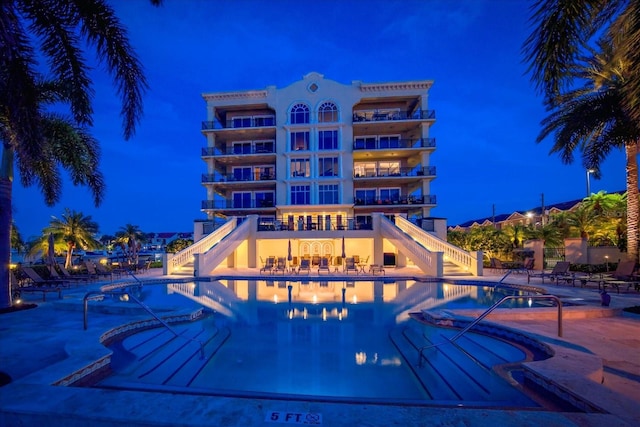 202 Windward Psge Unit 304, Clearwater Beach, FL 33767 - pool at twilight featuring stairway, a community pool, and a patio