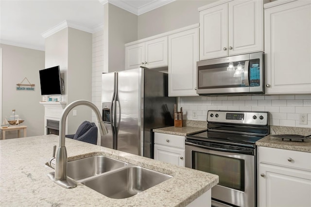 kitchen with tasteful backsplash, crown molding, white cabinets, a sink, and stainless steel appliances