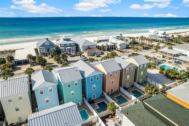 aerial view with a residential view, a view of the beach, and a water view