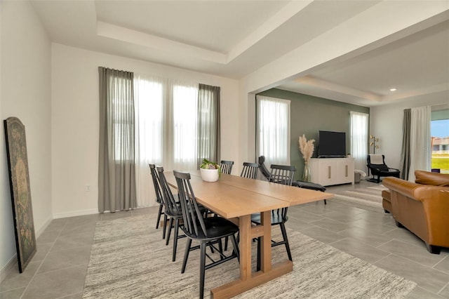 3504 Golden Wheat Ln, Plant City, FL 33565 - dining room featuring a raised ceiling, light tile patterned floors, and baseboards