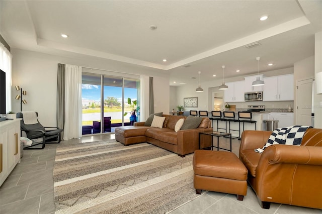 3504 Golden Wheat Ln, Plant City, FL 33565 - living room with a tray ceiling, recessed lighting, and light tile patterned floors