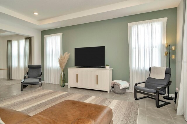 3504 Golden Wheat Ln, Plant City, FL 33565 - living room featuring light tile patterned floors, baseboards, recessed lighting, and a tray ceiling