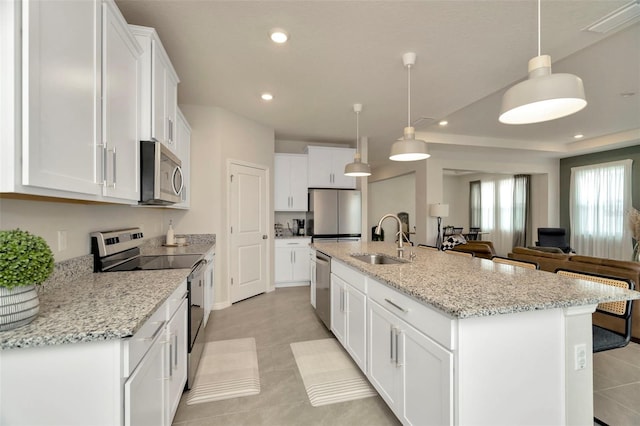 3504 Golden Wheat Ln, Plant City, FL 33565 - kitchen with appliances with stainless steel finishes, a sink, recessed lighting, white cabinetry, and a center island with sink