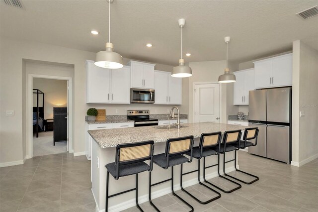3504 Golden Wheat Ln, Plant City, FL 33565 - kitchen featuring stainless steel appliances, a sink, recessed lighting, a breakfast bar area, and light tile patterned floors