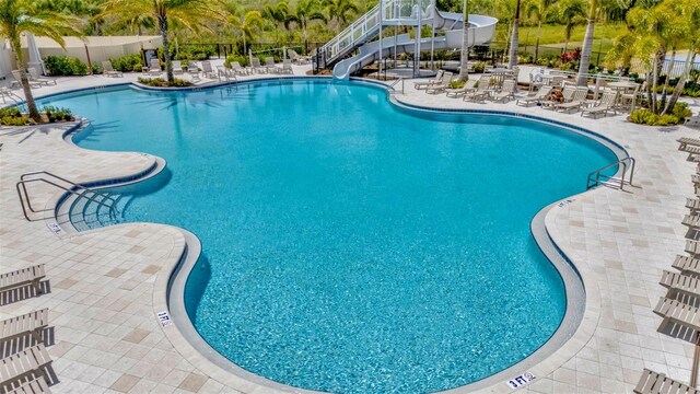 3504 Golden Wheat Ln, Plant City, FL 33565 - community pool with a water slide, a patio, and view of wooded area
