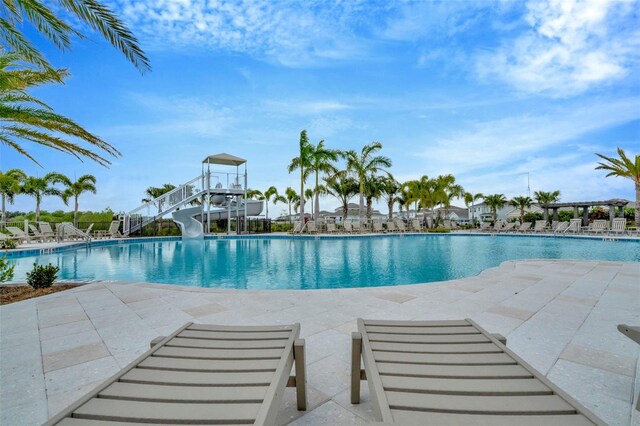 3504 Golden Wheat Ln, Plant City, FL 33565 - community pool featuring a water slide and a patio
