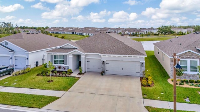 3504 Golden Wheat Ln, Plant City, FL 33565 - single story home with a residential view, a garage, driveway, and roof with shingles