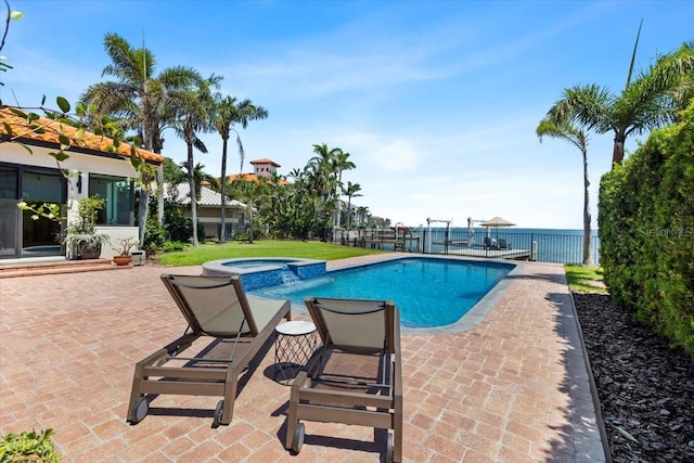 view of pool with fence, a patio area, and a pool with connected hot tub