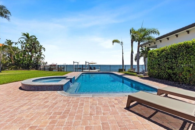 view of pool featuring fence, a patio, and a pool with connected hot tub
