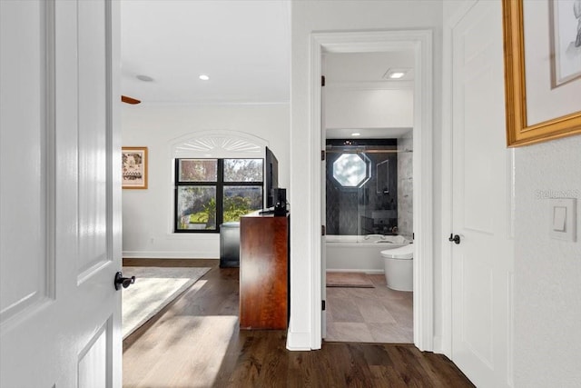 hall featuring baseboards, ornamental molding, and dark wood-style floors