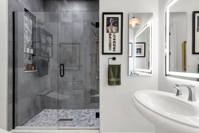 bathroom with a stall shower and a sink