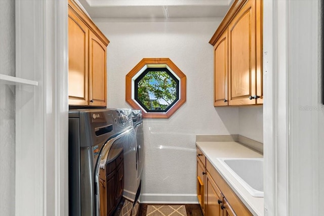 clothes washing area featuring baseboards, a sink, and cabinet space
