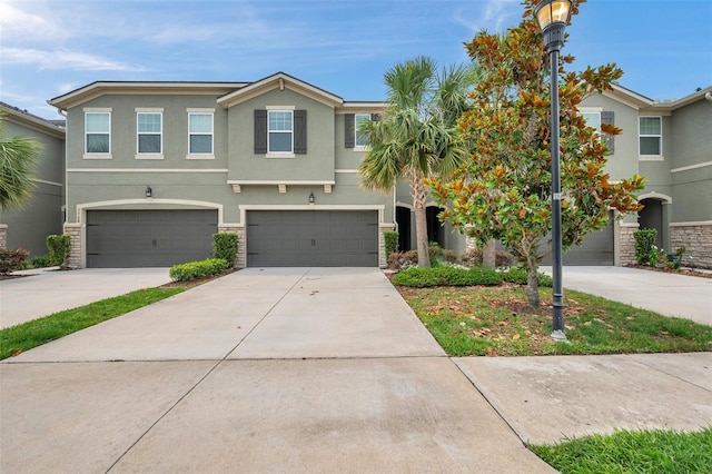 5710 Grand Sonata Ave, Lutz, FL 33558 - townhome / multi-family property with stucco siding, driveway, stone siding, and an attached garage