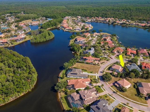 birds eye view of property featuring a water view, a residential view, and a view of trees
