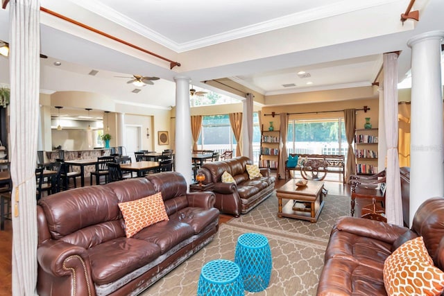 living area featuring ornamental molding, ceiling fan, and ornate columns