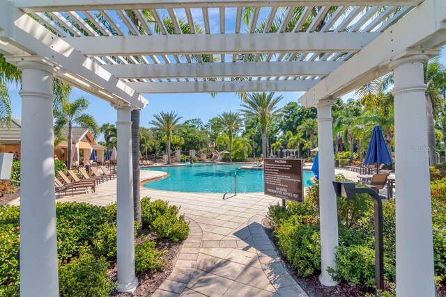 community pool with a pergola and a patio
