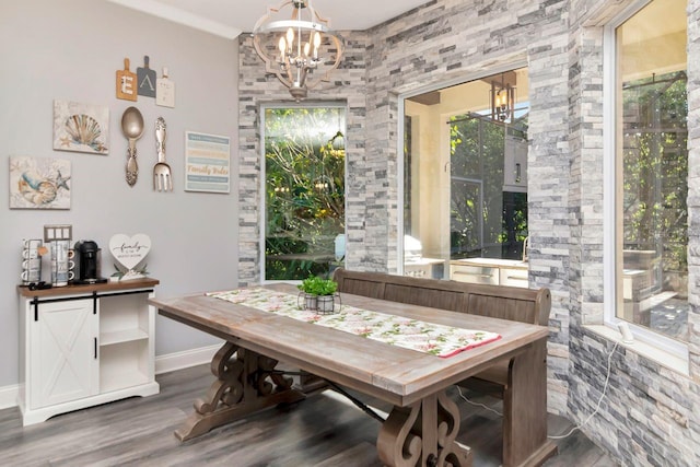 dining area featuring a notable chandelier, wood finished floors, and baseboards