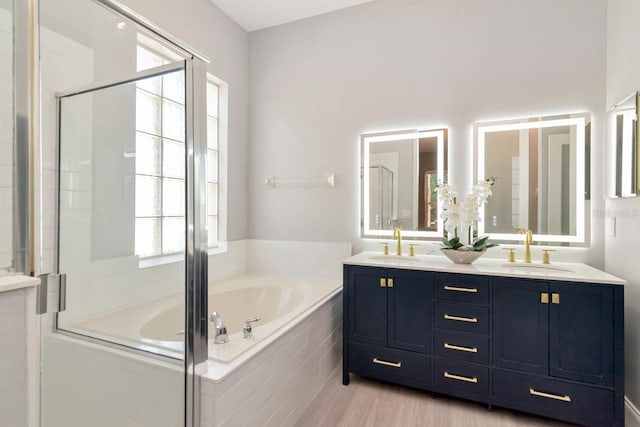 full bathroom featuring a bath, a sink, and a shower stall