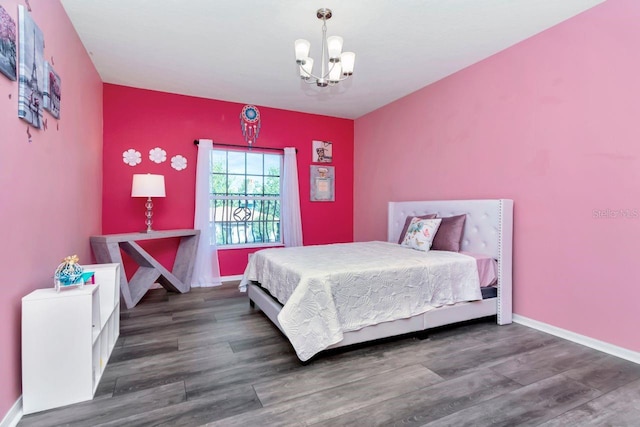 bedroom with an inviting chandelier, wood finished floors, and baseboards
