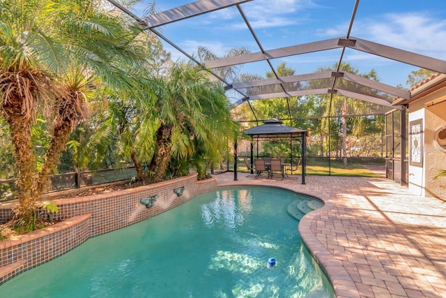 pool featuring a patio, a gazebo, and glass enclosure