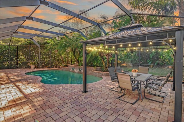 outdoor pool with a gazebo, a lanai, and a patio area
