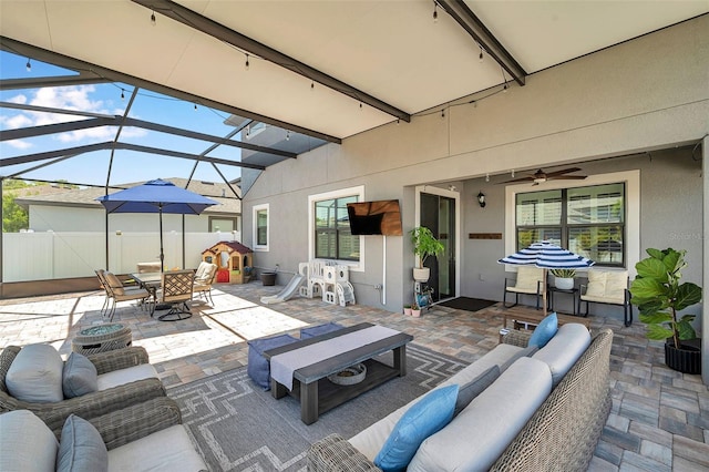 view of patio / terrace featuring a lanai, ceiling fan, an outdoor hangout area, and outdoor dining space