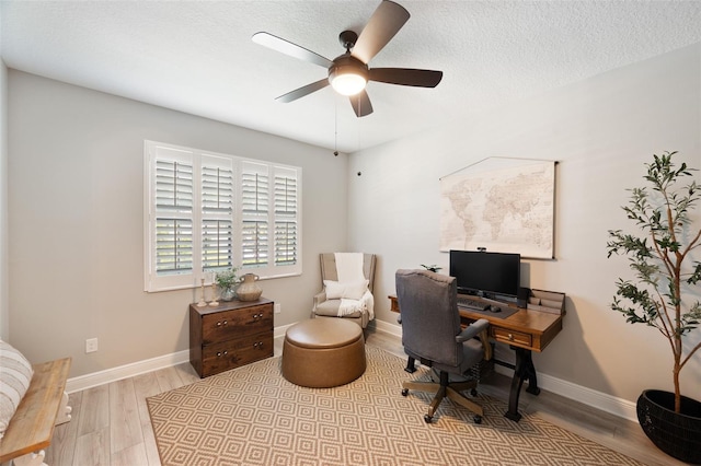 home office featuring wood finished floors, a textured ceiling, baseboards, and ceiling fan