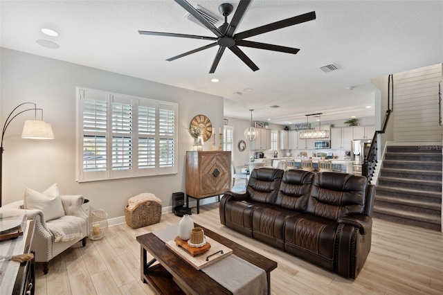 living room with stairs, ceiling fan, light wood-style flooring, visible vents, and recessed lighting