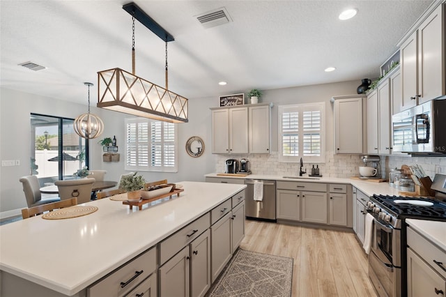 kitchen featuring visible vents, appliances with stainless steel finishes, decorative backsplash, and a sink