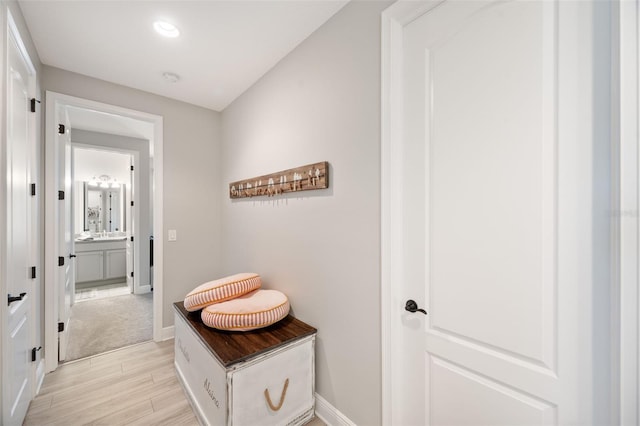 corridor with recessed lighting, light wood-style floors, and baseboards