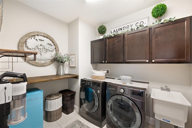 washroom featuring tile patterned floors, a sink, baseboards, independent washer and dryer, and cabinet space