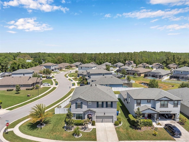 drone / aerial view featuring a residential view and a wooded view