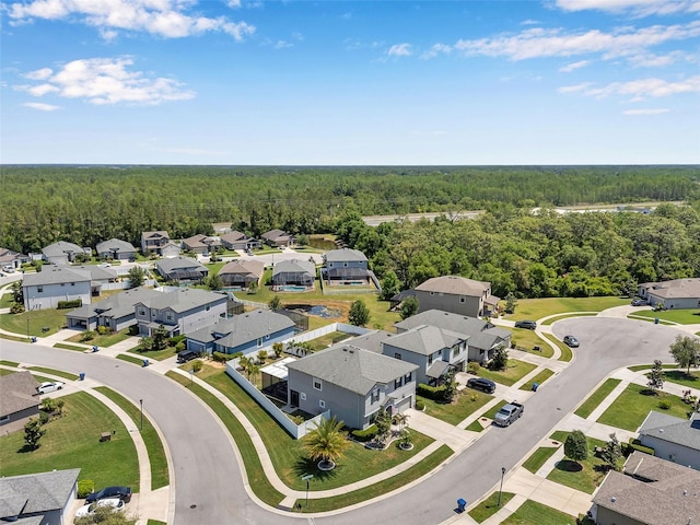 drone / aerial view with a residential view and a wooded view